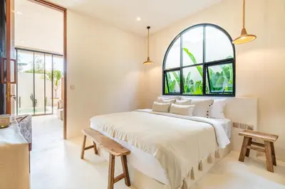 a bedroom with a large bed and an arched window at Casa Admire Villas in Legian