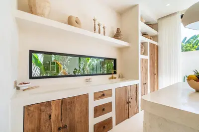 a kitchen with a flat screen tv on the wall at Casa Admire Villas in Legian