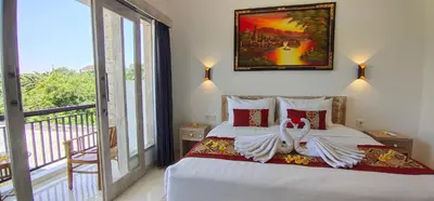 a bedroom with a bed and a large window at The Lebak Sari Guesthouse in Umalas