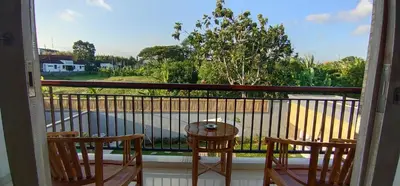 a balcony with a table and chairs and a view of a street at The Lebak Sari Guesthouse in Umalas