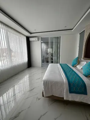 a bedroom with a large bed and a large window at newly built Villa Na Bali in Seminyak