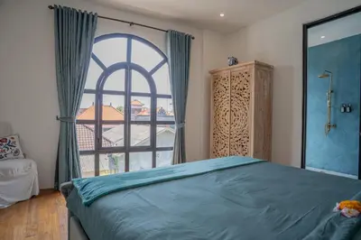a bedroom with a bed and a large window at Villa Rhapsody Seminyak in Seminyak