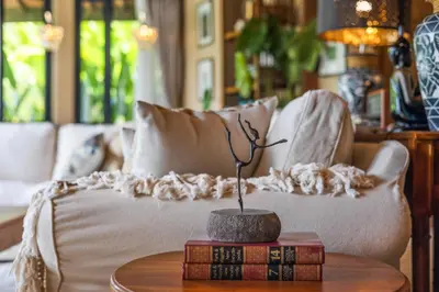 a living room with a couch and a table with books at Luxurious Arakana Villa with Pool in Jimbaran