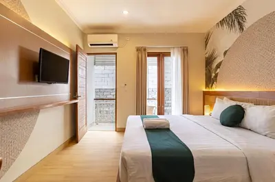 a bedroom with a large bed and a flat screen tv at Cove Vin Stay in Sanur
