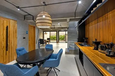 a kitchen with a black table and blue chairs at Atelier 1Br Villas in Seminyak in Seminyak
