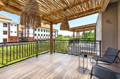 a balcony with chairs and a view of a building at Atelier 1Br Villas in Seminyak in Seminyak