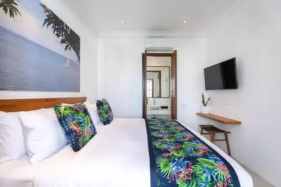 a bedroom with a white bed with colorful pillows at Gorgeous 2 Bed Pool Villa, Walk to Seminyak Beach in Seminyak