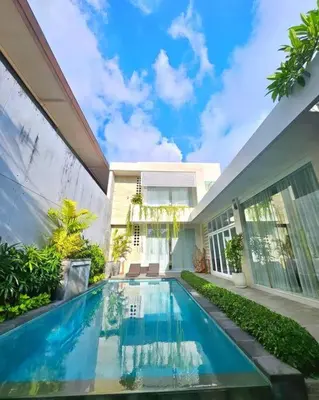 a swimming pool in front of a house at Nikaya Villa - 3 Bedrooms Near Seminyak in Legian