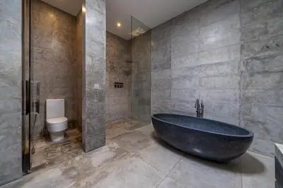 a bathroom with a large tub and a toilet at Villa Simpatico Spacious 6 BR Villa Retreat in Central Seminyak in Seminyak