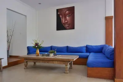 a living room with a blue couch and a table at T&J1 - Gorgeous 1BR pool villa, parking, walk to beach! in Umalas