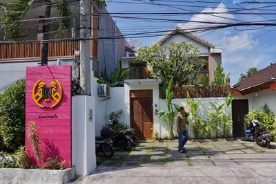 a person walking in front of a house with a pink wall at T&J1 - Gorgeous 1BR pool villa, parking, walk to beach! in Umalas