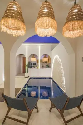 a swimming pool in a room with two chairs and chandeliers at T&J5 - New! Romantic 1BR pool villa, walk to beach! in Umalas