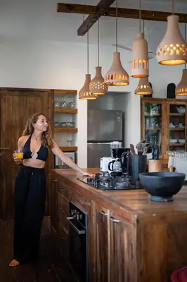 a woman is standing in a kitchen at Villa Belle Oasis - Next To Canggu 5BR Tropical Paradise with Private Pool & Stunning Rice Field Views in Kerobokan