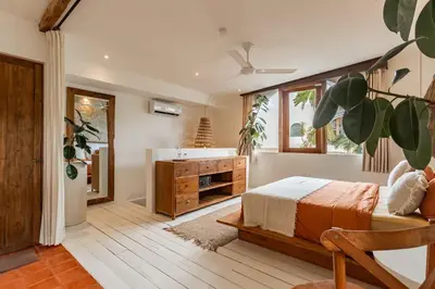 a bedroom with a bed and a bathroom with a tub at Villa Belle Oasis - Next To Canggu 5BR Tropical Paradise with Private Pool & Stunning Rice Field Views in Kerobokan