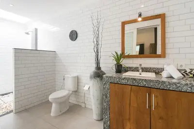 a bathroom with a toilet and a sink and a mirror at 2 villa complex near Atlas beach in Canggu