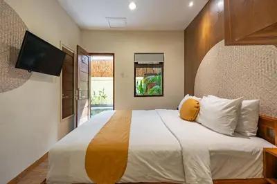 a bedroom with a large bed with a flat screen tv at Cove Kavana in Canggu