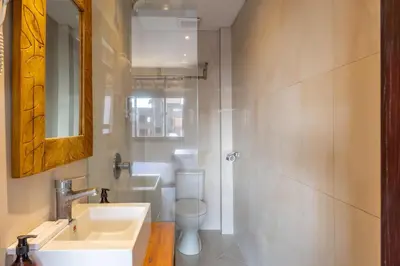 a bathroom with a sink and a toilet and a mirror at Cove Kavana in Canggu