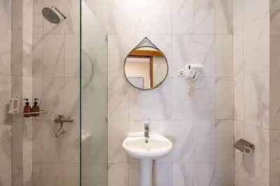 a bathroom with a sink and a mirror and a shower at Cove Kavana in Canggu