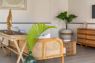 a living room with a table and a plant in a vase at Free pick-up Balinese style tropical private pool villa with 2 bedrooms in Seminyak