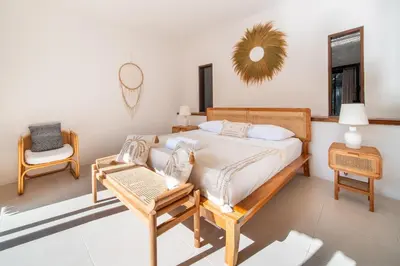 a bedroom with a bed and a chair and a mirror at Free pick-up Balinese style tropical private pool villa with 2 bedrooms in Seminyak
