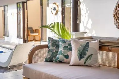 a couch with pillows on it in a living room at Free pick-up Balinese style tropical private pool villa with 2 bedrooms in Seminyak