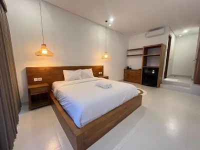 a bedroom with a large bed and two lights at Braban Sari Bali in Seminyak