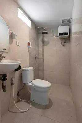 a bathroom with a toilet and a sink and a shower at Braban Sari Bali in Seminyak