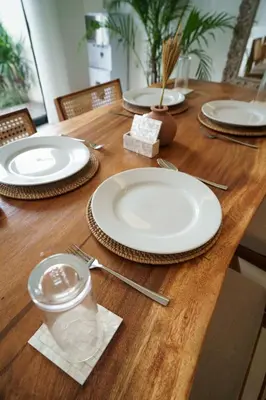 a wooden table with plates and utensils on it at Canggu Zen Villa - 2 BR Villa in Berawa in Canggu