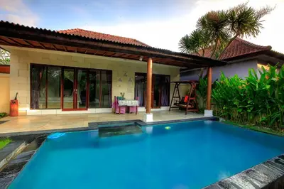 a swimming pool in front of a villa at LV Villa Kuta Bali in Jimbaran