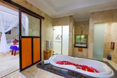 a bathroom with a large tub filled with red flowers at LV Villa Kuta Bali in Jimbaran