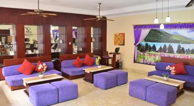 a living room with purple couches and a large painting at LV Villa Kuta Bali in Jimbaran