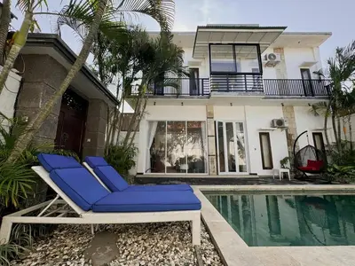a pair of blue lounge chairs next to a swimming pool at Bby Diamond Villa in Seminyak