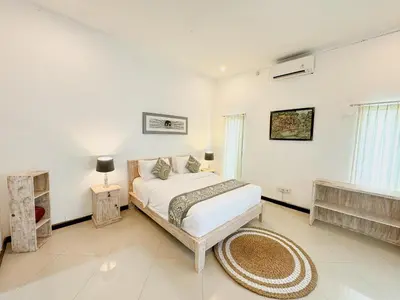 a white bedroom with a bed and a fireplace at Bby Diamond Villa in Seminyak