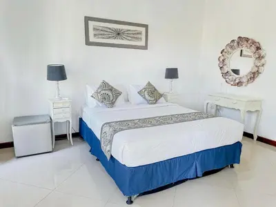 a bedroom with a bed and two tables and a mirror at Bby Diamond Villa in Seminyak