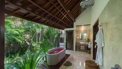 a bathroom with a bath tub and a garden at Villa Asta in Seminyak