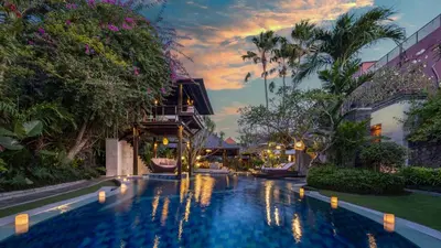a pool in the middle of a building with trees at Villa Asta in Seminyak