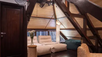 a attic room with a couch and a chair at Villa Asta in Seminyak