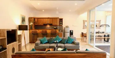 a living room with a couch and a kitchen at 3 neighbour villas 3 pools near Atlas Beach Club in Canggu