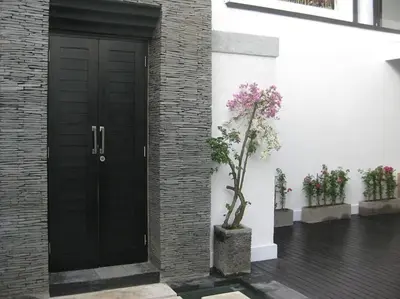 a black door with a potted plant next to a building at Le Retreat Canggu, 3BR Luxury Villa, Bali's Best Location in Canggu