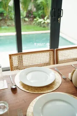 a white plate sitting on a wooden table at Berawa 2BR Private Pool Leon Villa by Bali Bliss Properties in Canggu