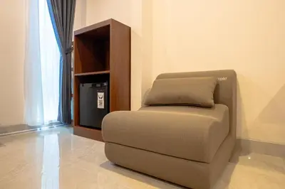 a chair sitting in a room next to a television at Miles Coliving in Kerobokan