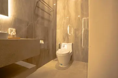 a bathroom with a toilet and a sink at Miles Coliving in Kerobokan