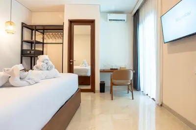 a hotel room with a bed and a television at Miles Coliving in Kerobokan