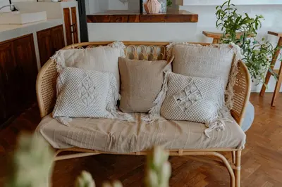 a wicker chair with pillows on it in a living room at Villa bossa nova in Seminyak