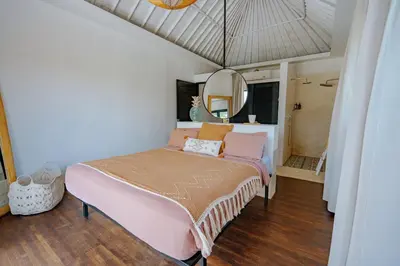 a bedroom with a pink bed and a mirror at Villa bossa nova in Seminyak