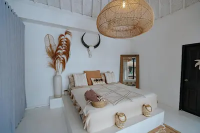 a bedroom with a large bed and a chandelier at Villa bossa nova in Seminyak