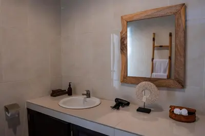 a bathroom with a sink and a mirror at Villa Yuhi in Seminyak