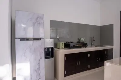 a kitchen with white marble counter tops and a refrigerator at Villa Yuhi in Seminyak