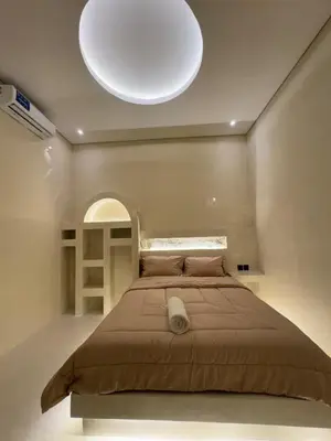 a bedroom with a large bed with a large light above it at Antanaya Villa Seminyak in Seminyak