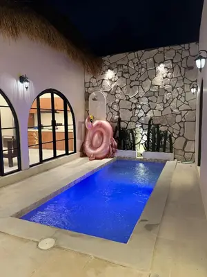 a pool with a pink pig sitting next to a house at Antanaya Villa Seminyak in Seminyak